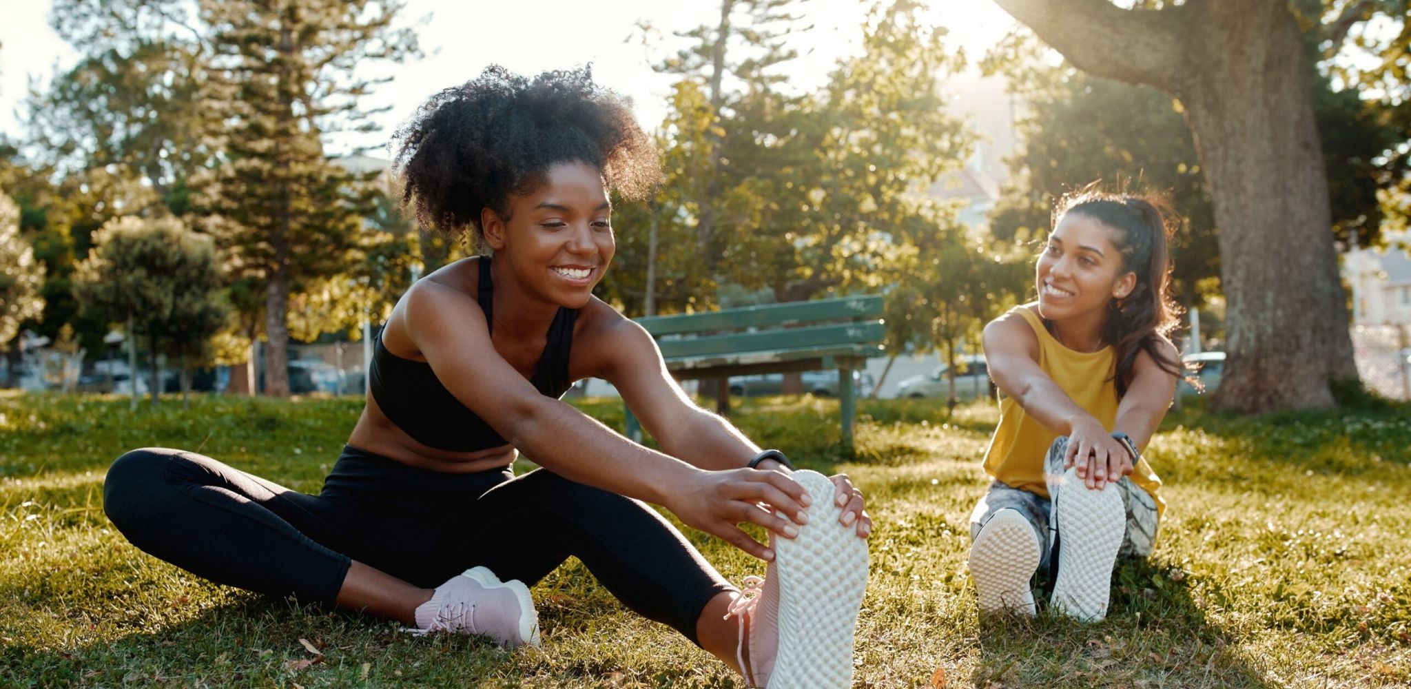 Hawthorne at South Hartmann female diverse friends doing stretching exercise in the park - diverse friends warming up before doing group exercise